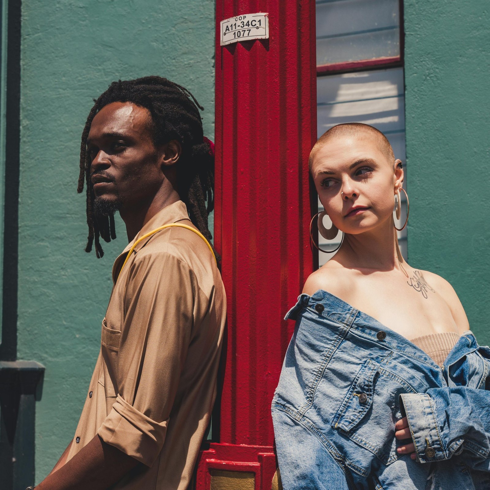 Stylish urban photoshoot featuring diverse male and female models posing against a vibrant wall.